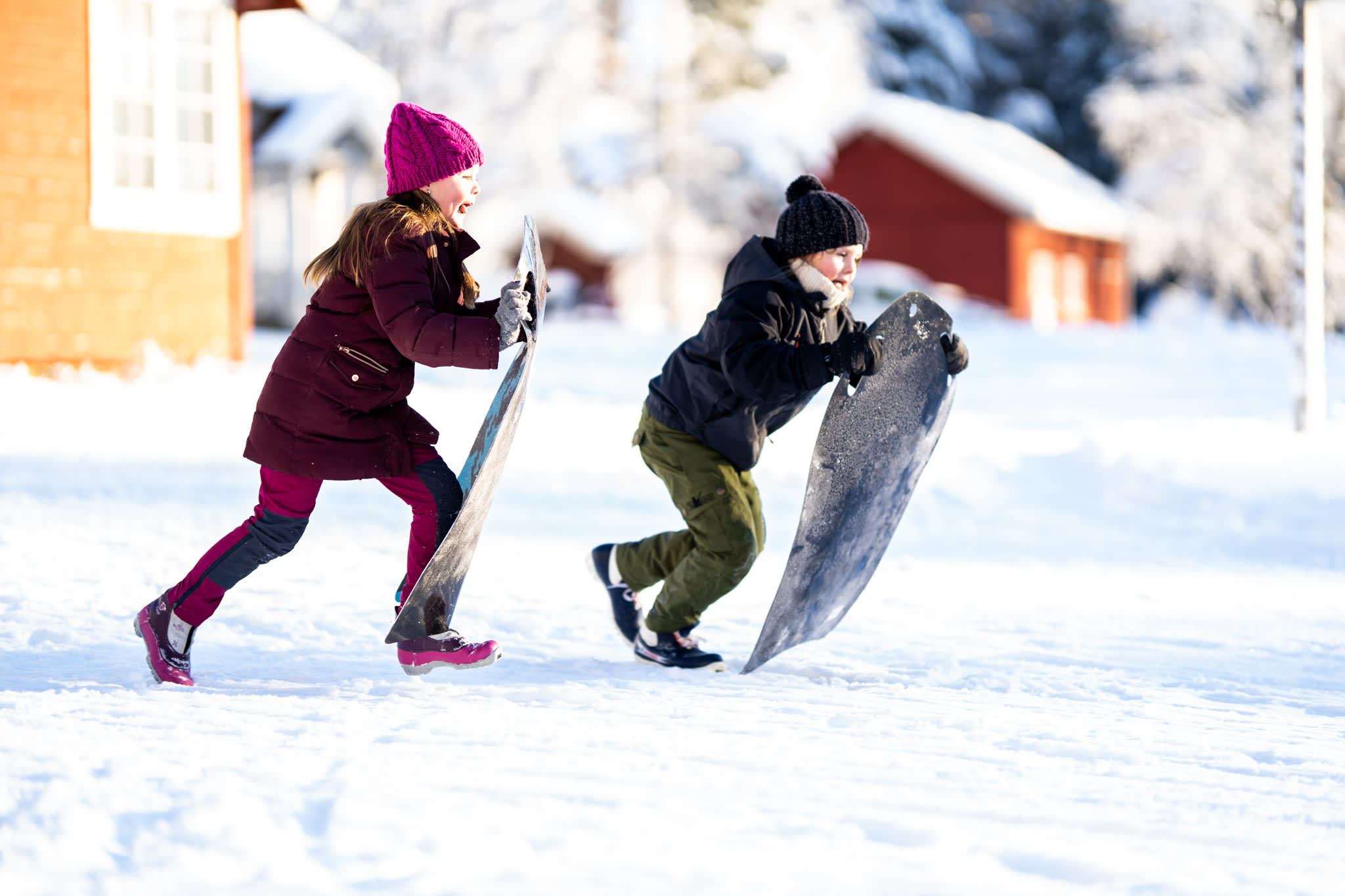 Two girls running with a toboggan to speed down the hill