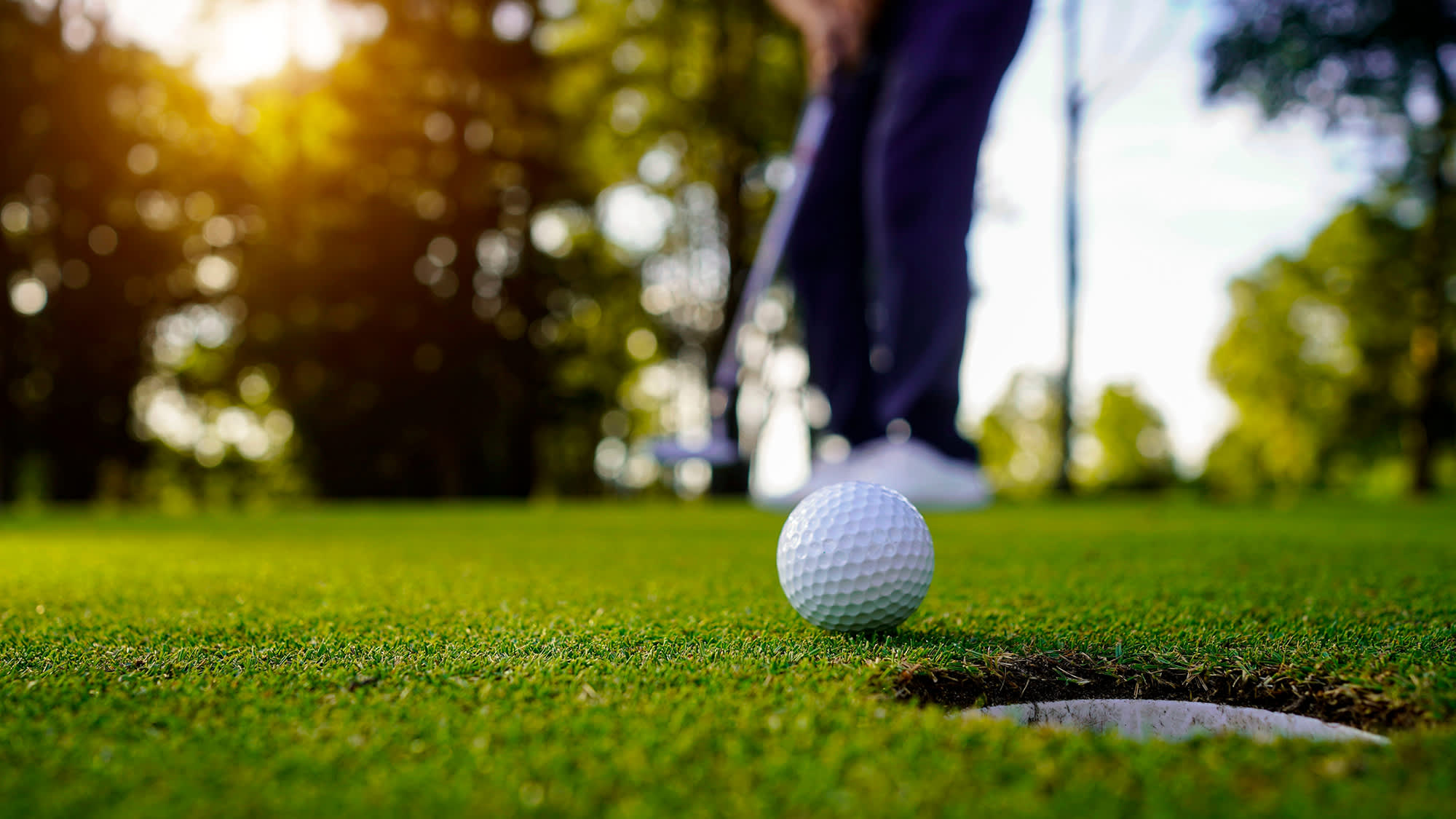 Golfball foran et hull på golfbanen