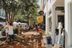 People shopping at a sidewalk sale on a sunny day