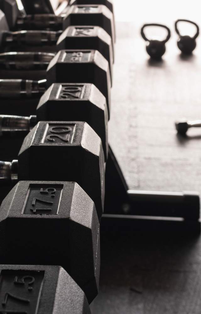 Dumbbells and kettlebells on a gym floor