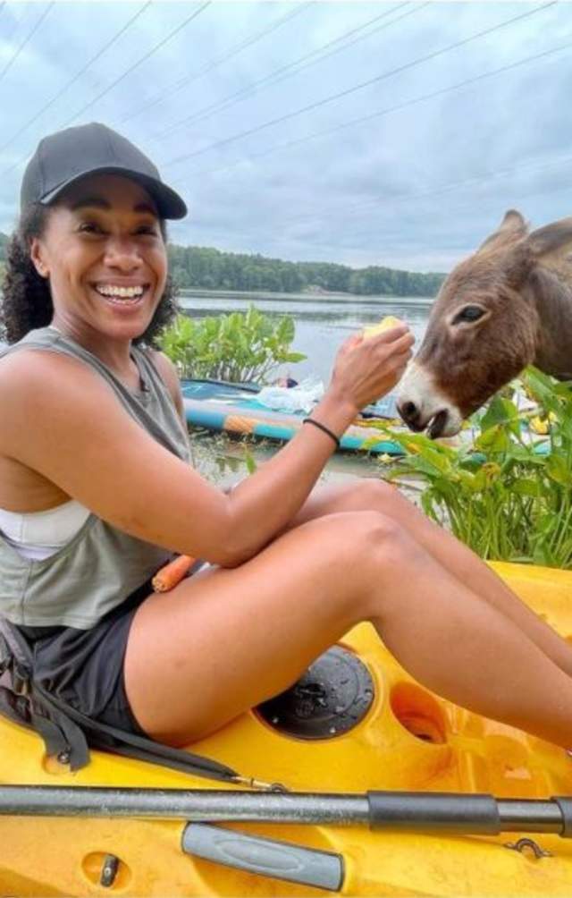 woman in Kayak feeding a Donkey on Stallings Island