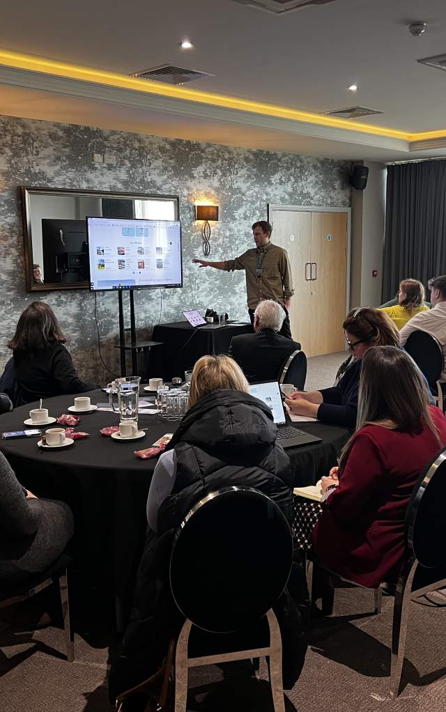 A networking event with man presenting from screen