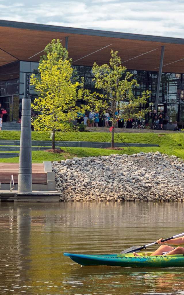 Man kayaking solo on St. Marys River in Fort Wayne, Indiana in front of Promenade Park