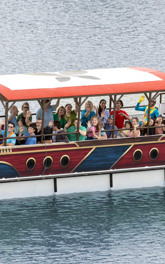 Group of people on covered boat waving