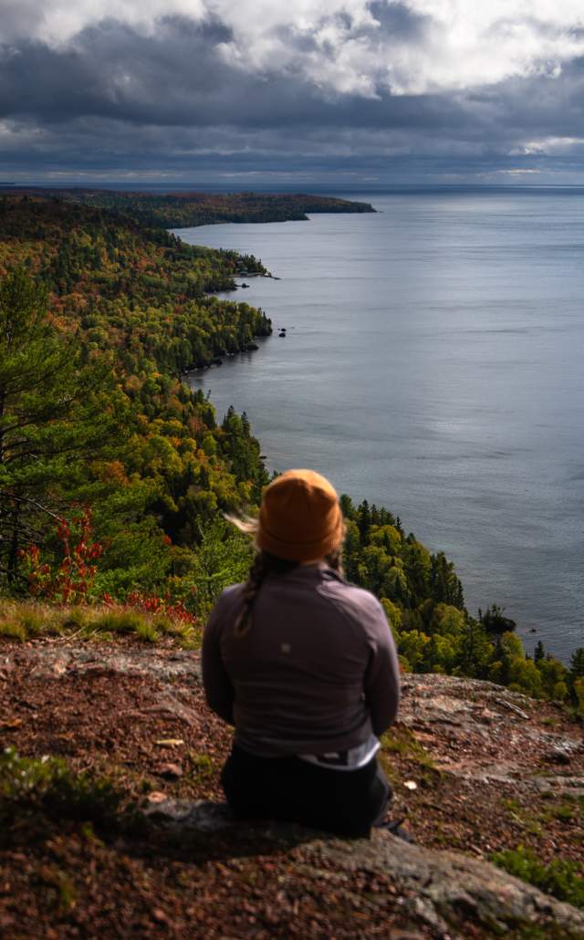 Person looking out over the tip of the Keweenaw from Bare Bluff in the fall