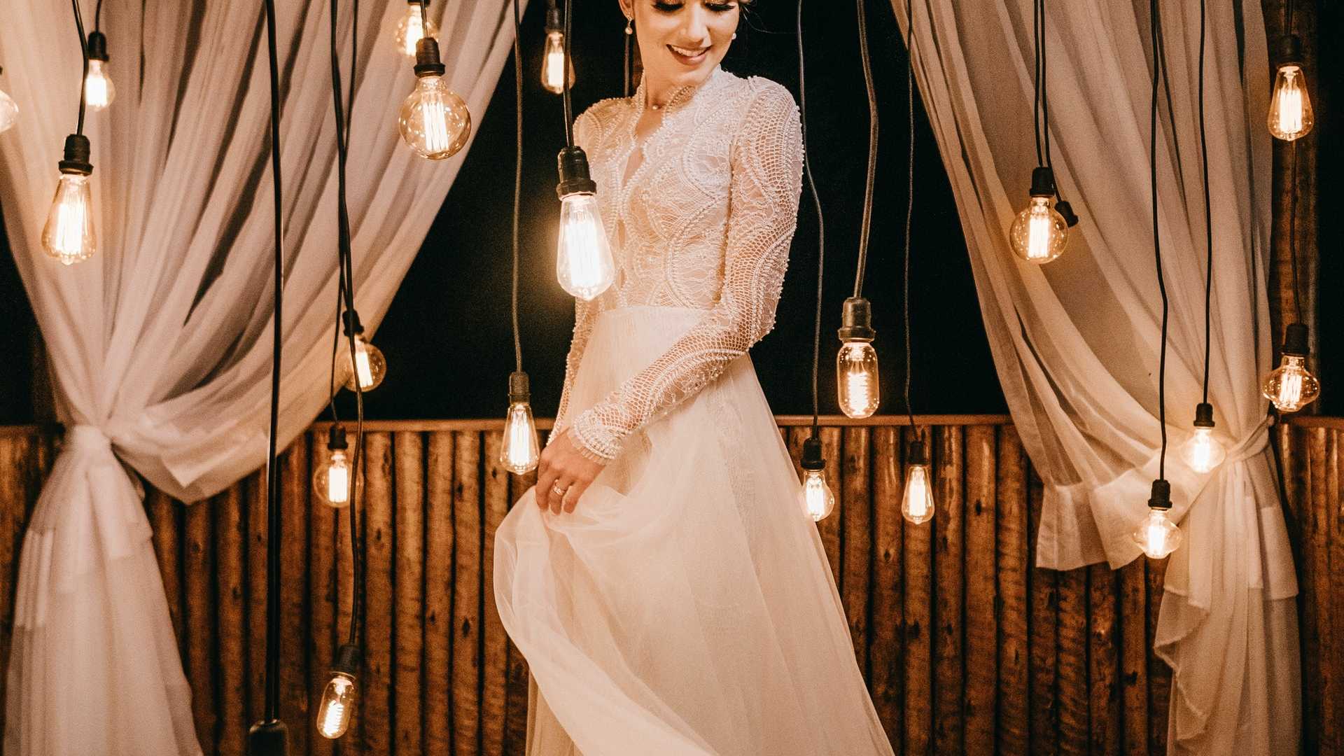 Bride in wedding gown among hanging lights
