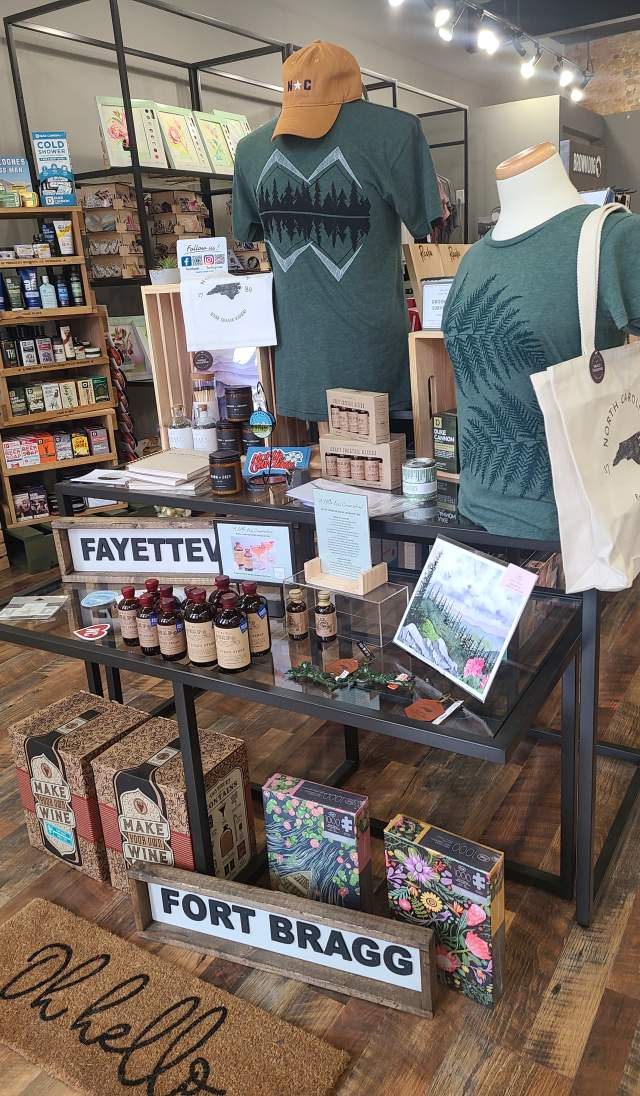 Merchandise display inside Reverie featuring Fayetteville and Fort Bragg–themed apparel, gifts, and locally made products.