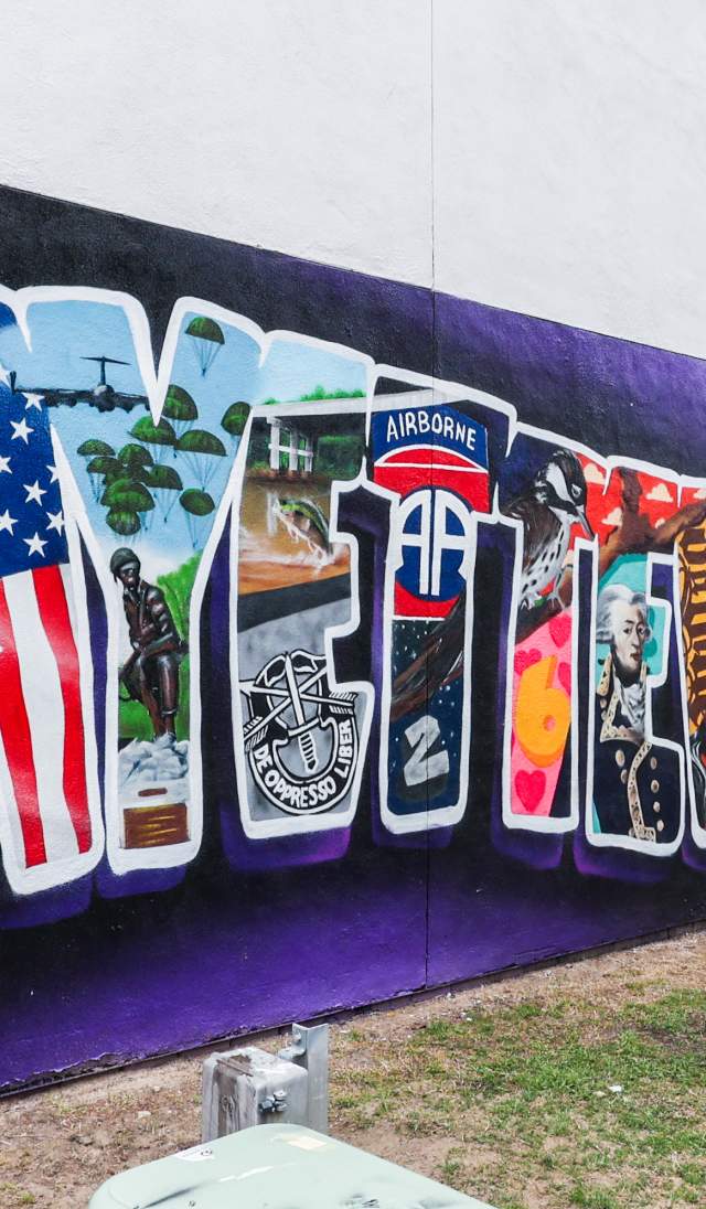 Welcome to Fayetteville Mural featuring J. Cole – A mural with imagery honoring the city’s history and J. Cole’s Dreamville brand