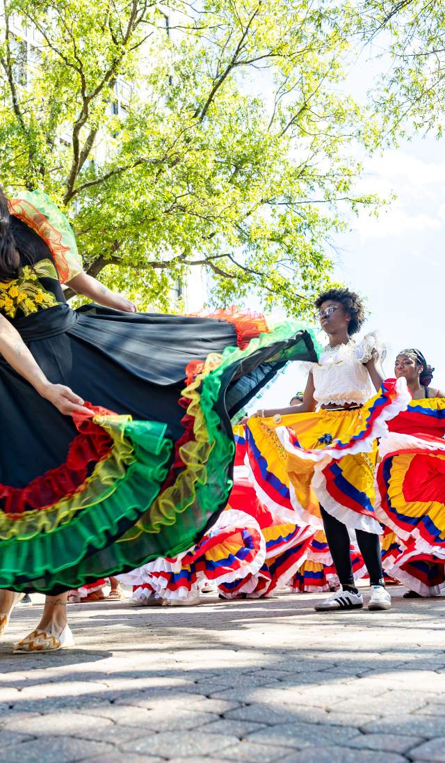 Colorful dancers performing traditional cultural dances during the Parade of Nations during the International Folk Festival in downtown Fayetteville, NC.