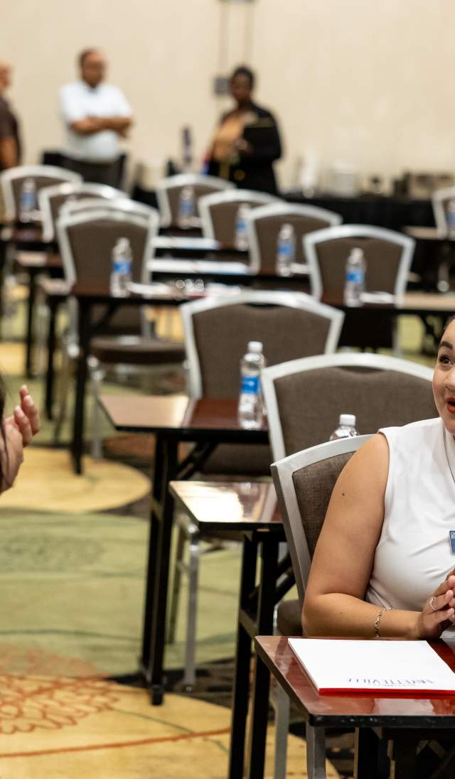 Two women conversing at a meeting