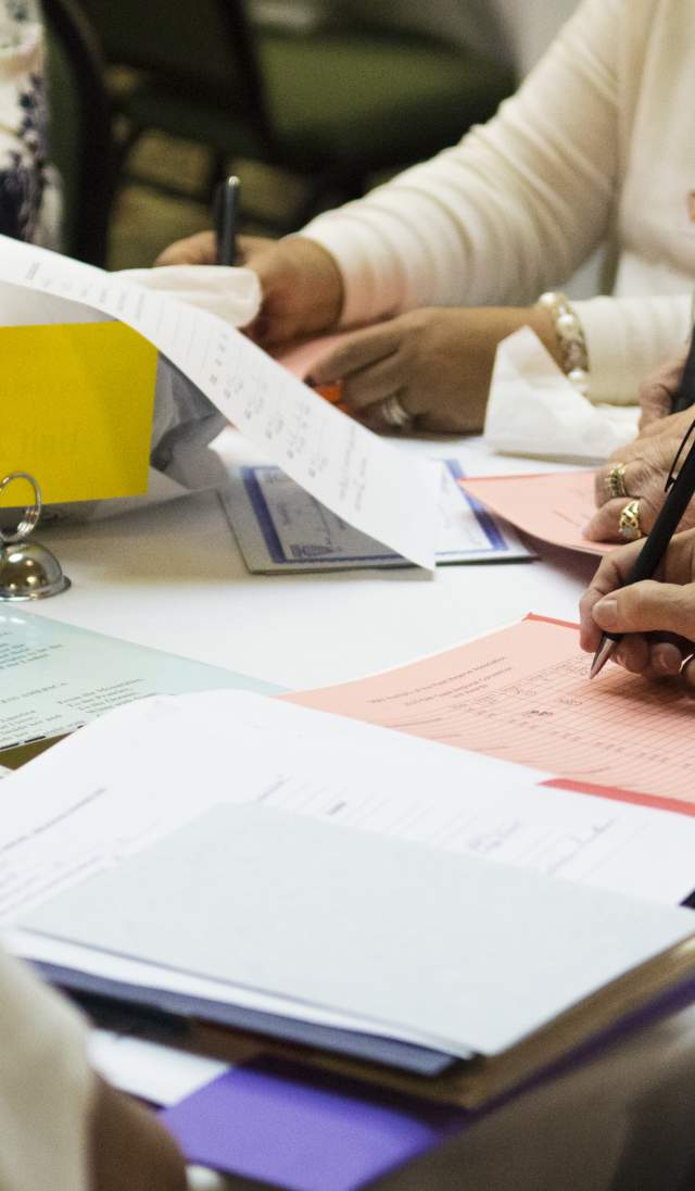 Image of a group of people taking notes at a meeting