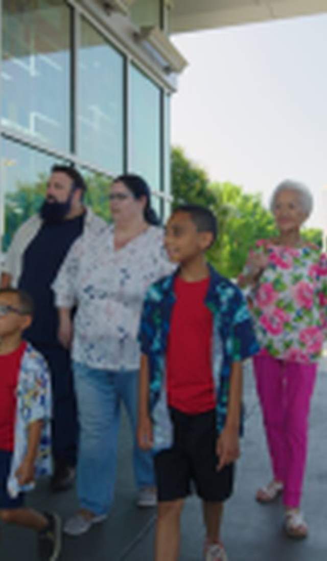 Multi-Generational family visiting Fayetteville's Veterans' Park with the ASOM in the background