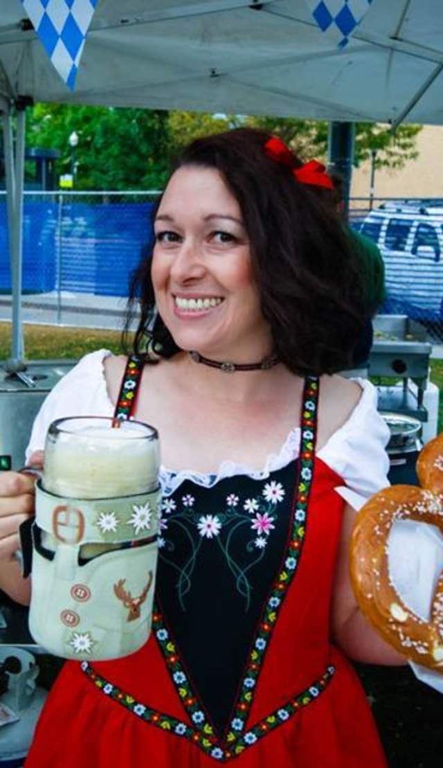 Woman holding a beer stein and pretzel at Oktobrewfest