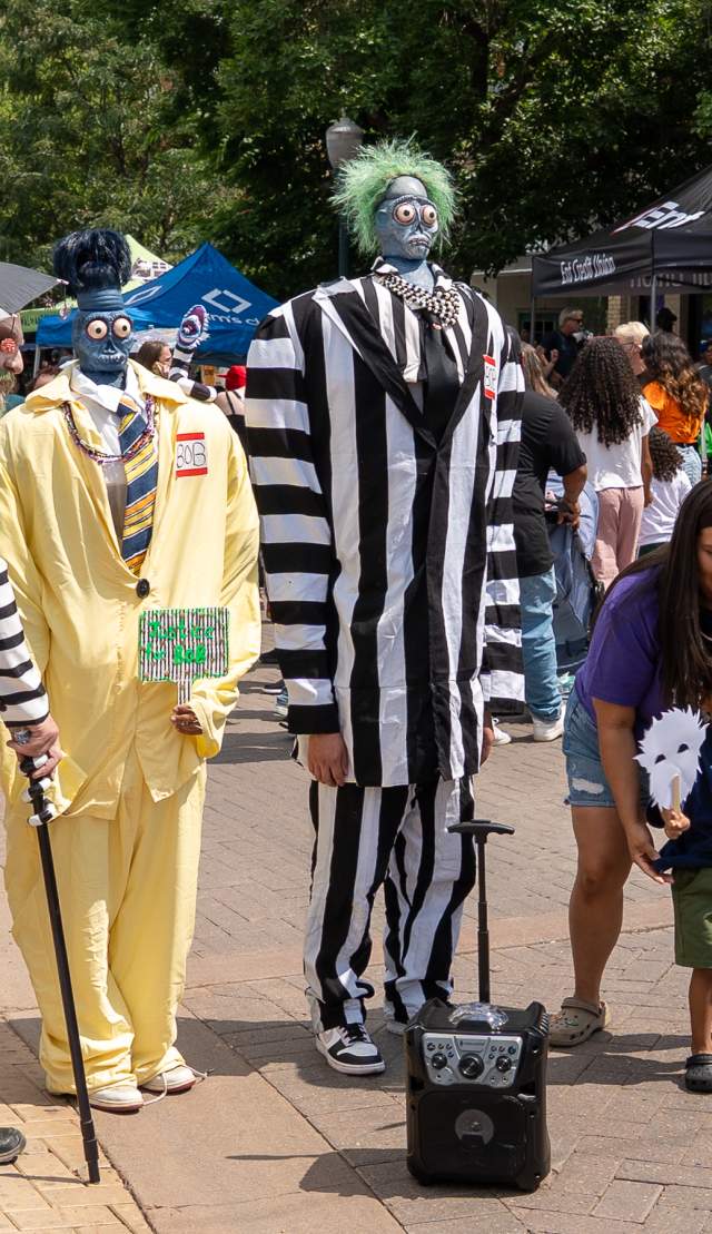 Child and mother posing with dressed up cast of Beetlejuice