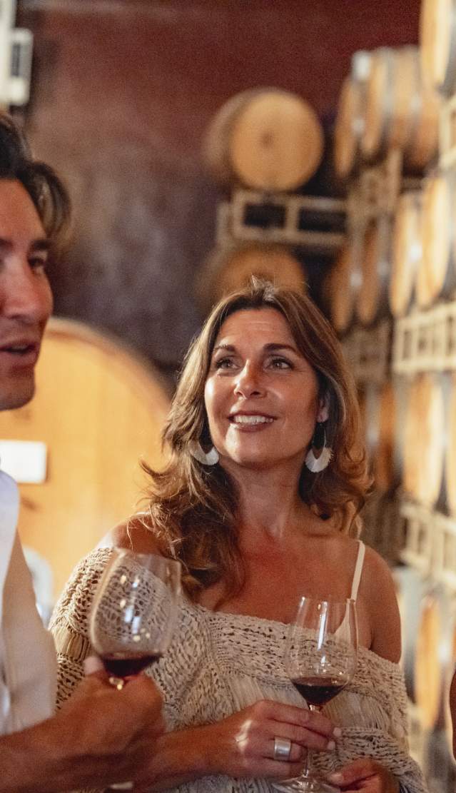 Couple and a few friends wine tasting in the barrel room at Ponte Vineyard in Temecula