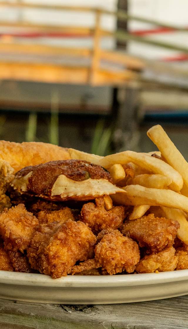 a plate of Calabash style seafood and fries on an outdoor railing in Calabash, NC