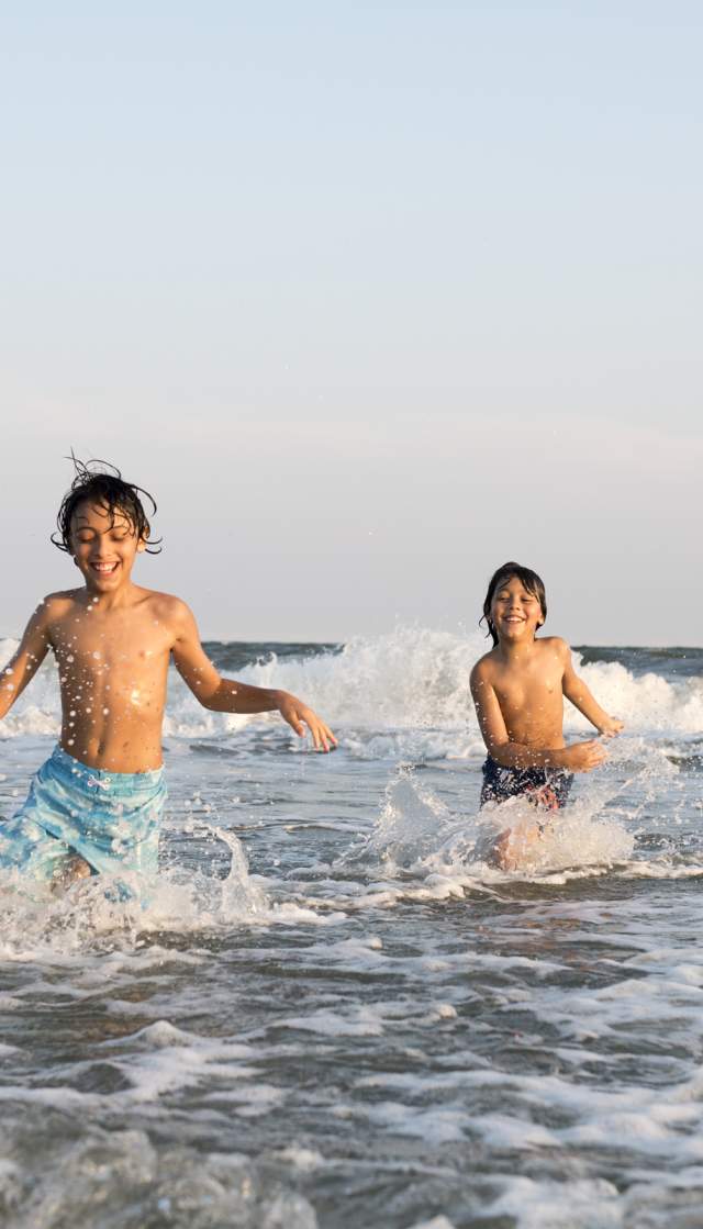 Boys playing in the surf at family friendly beach