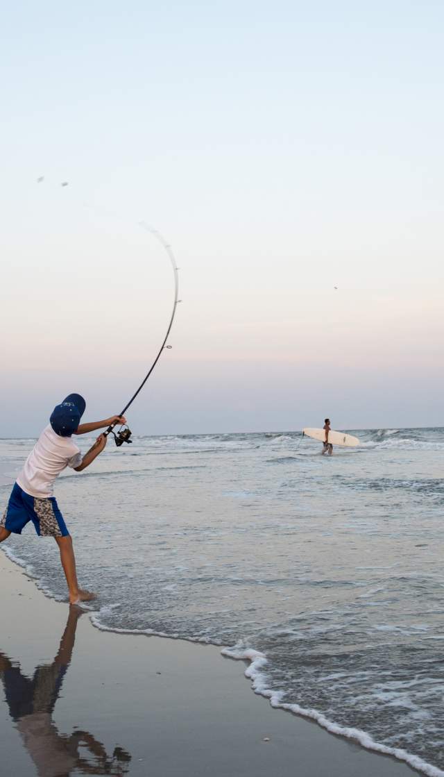 Boy surf fishing on Ocean Isle Beach