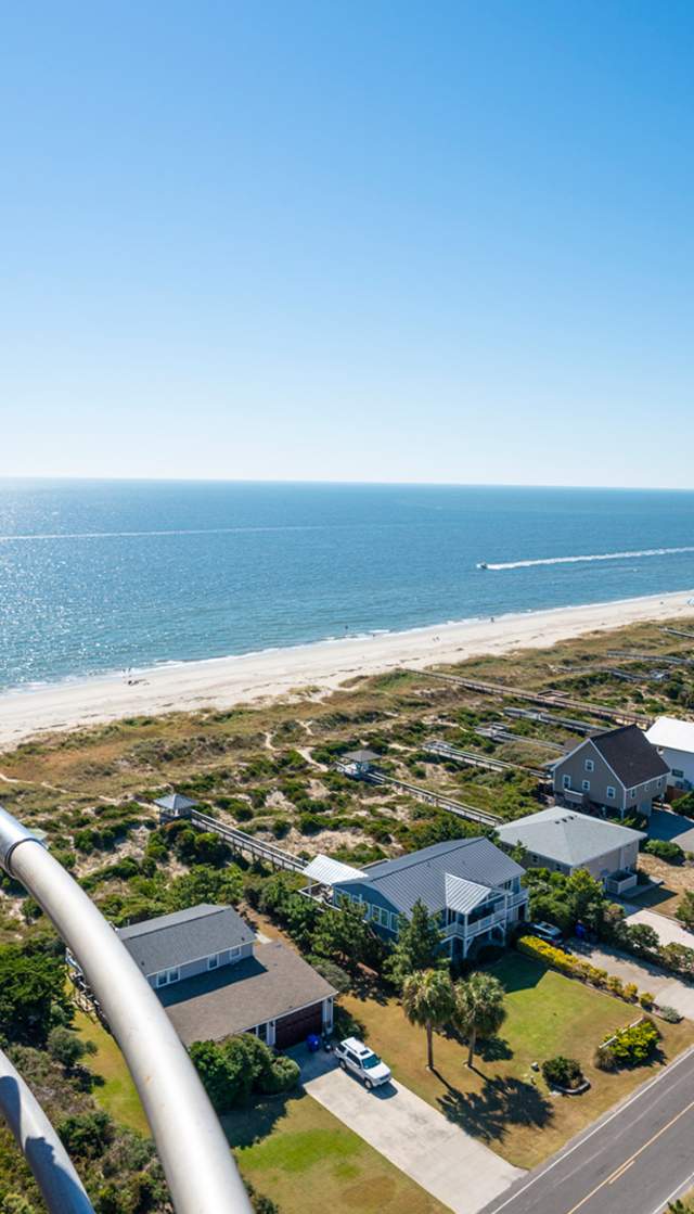 a father and daughter overlooking Caswell Beach from the top of the Oak Island Lighthouse