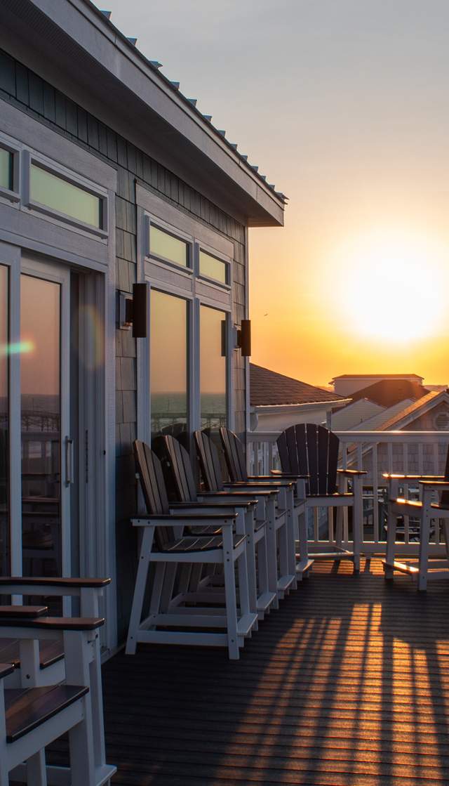 a view of Oak Island and a pier at sunrise from the deck of a vacation rental home