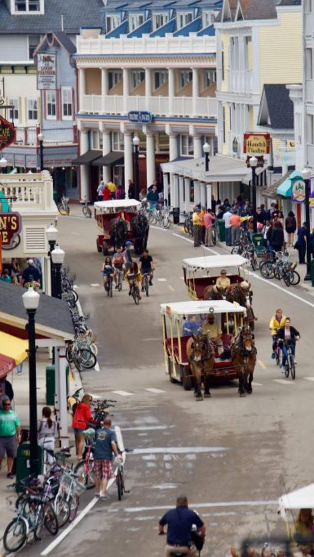 Pedestrians, bicycles and horse-drawn carriages make their way down Main Street in downtown Mackinac Island