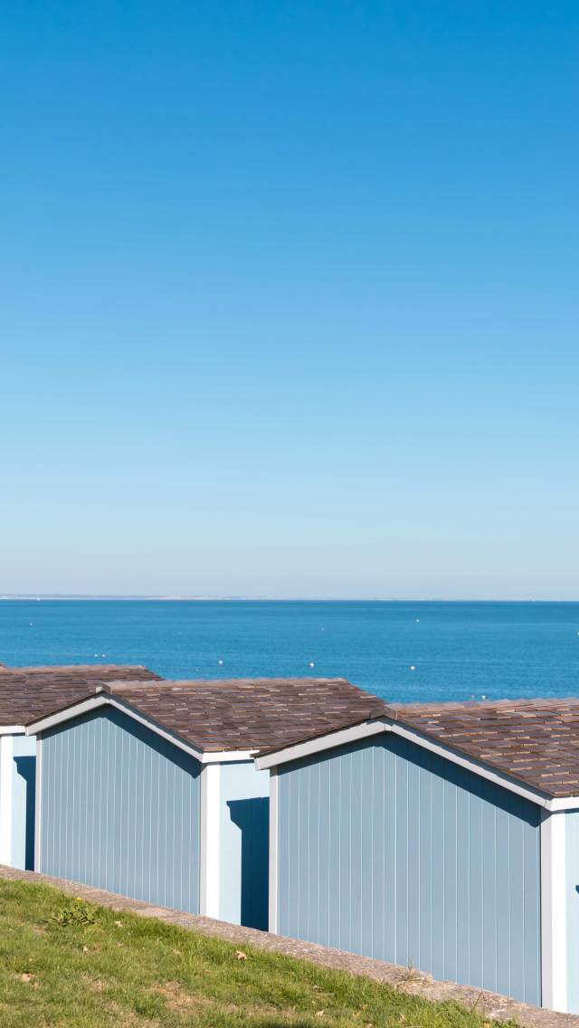 View of Swanage Bay in Dorset behind five blue beach huts