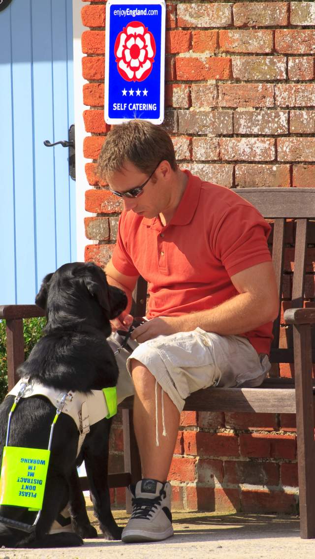 A man and his guide dog staying at a self catering holiday cottage in Dorset