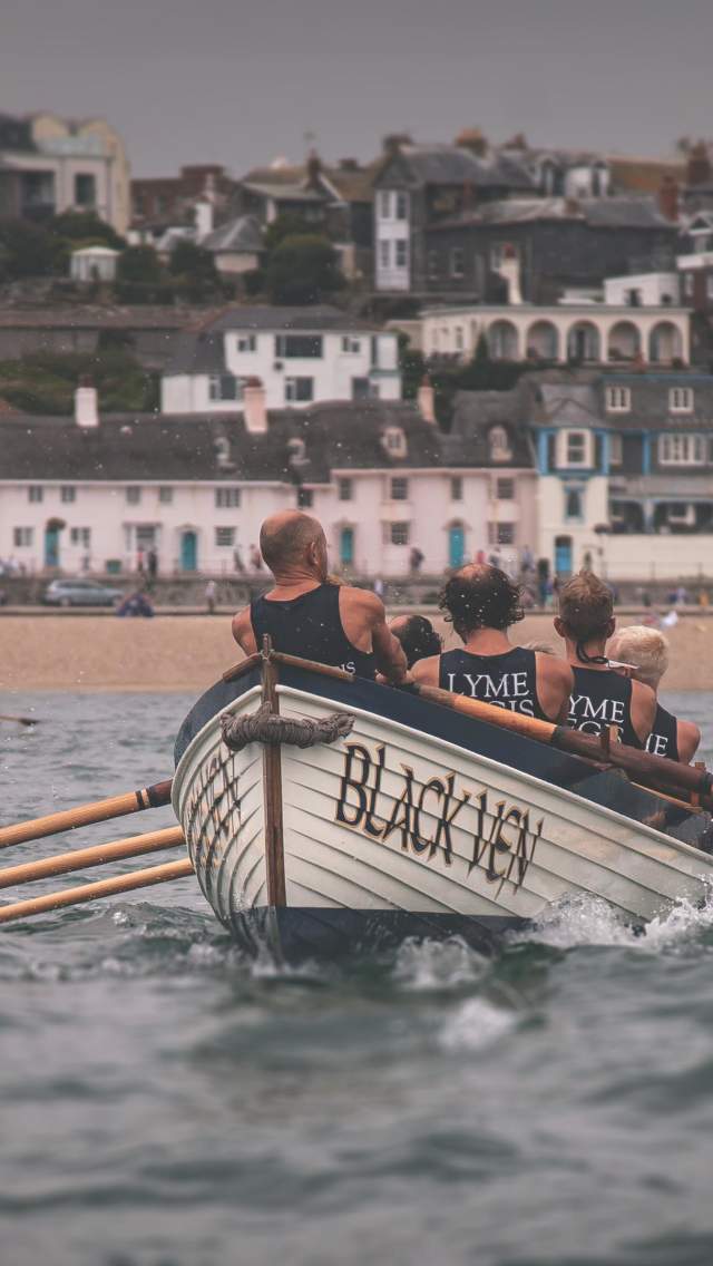 A group of boats racing at Lyme Regis gig regatta