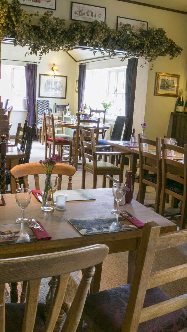 Tables and chairs inside The Saxon Arms pub in Stratton, Dorset