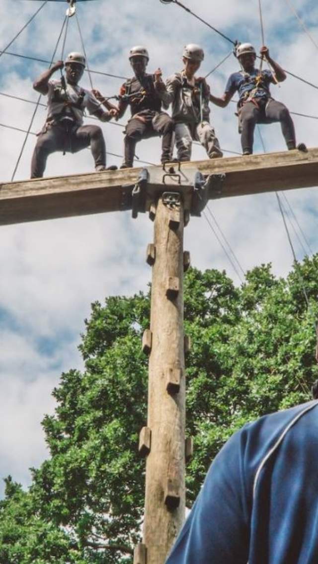 Four people taking part in a high ropes course with Cumulus Outdoors