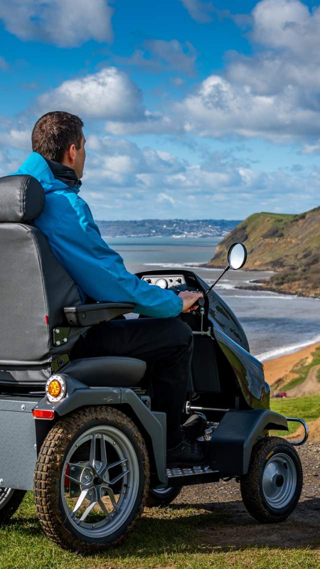 Man in a mobility scooter looking out over the Jurassic Coast in West Dorset