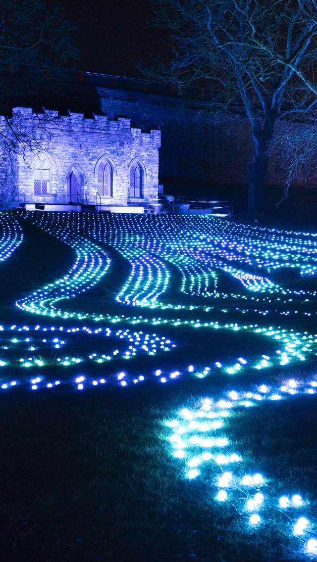 The grounds of Lincoln Cathedral illuminated with blue lights, laid out in a pattern on the ground