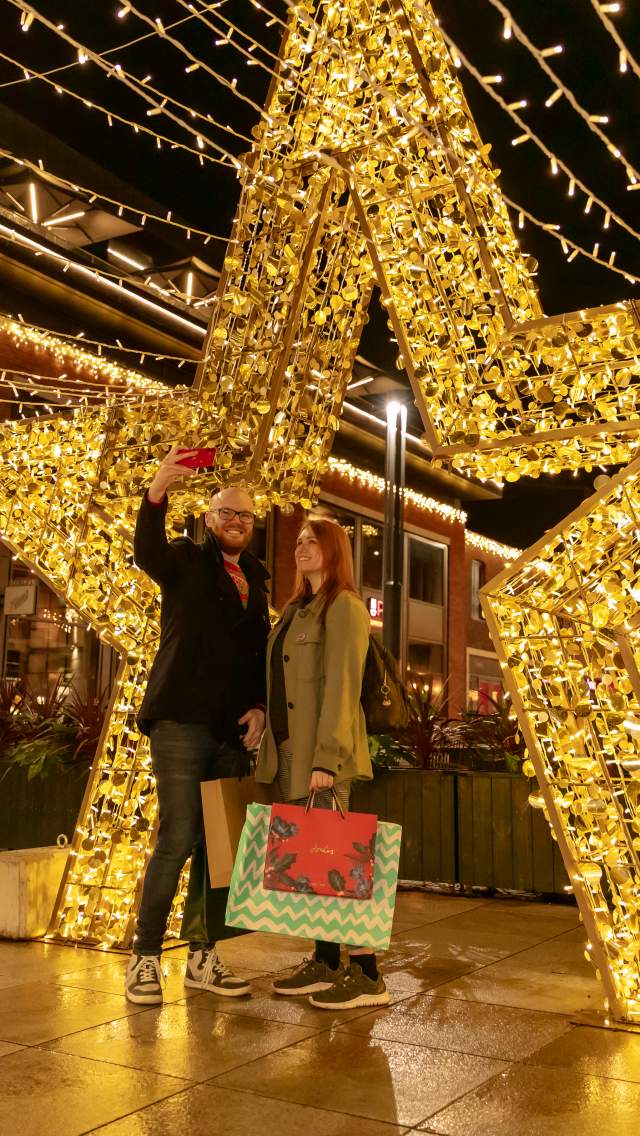 Couple posing in front of star lighting display in the cornhill