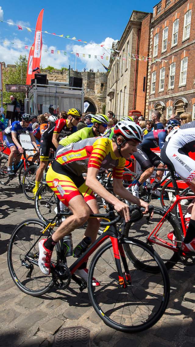 A group of male cyclists race through Castle Square, as part of the Lincoln Grand Prix.