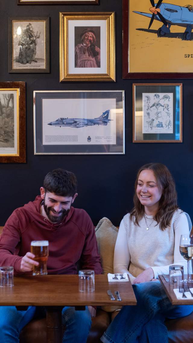A couple laugh while enjoying a drink in the Wig & Mitre in Lincoln