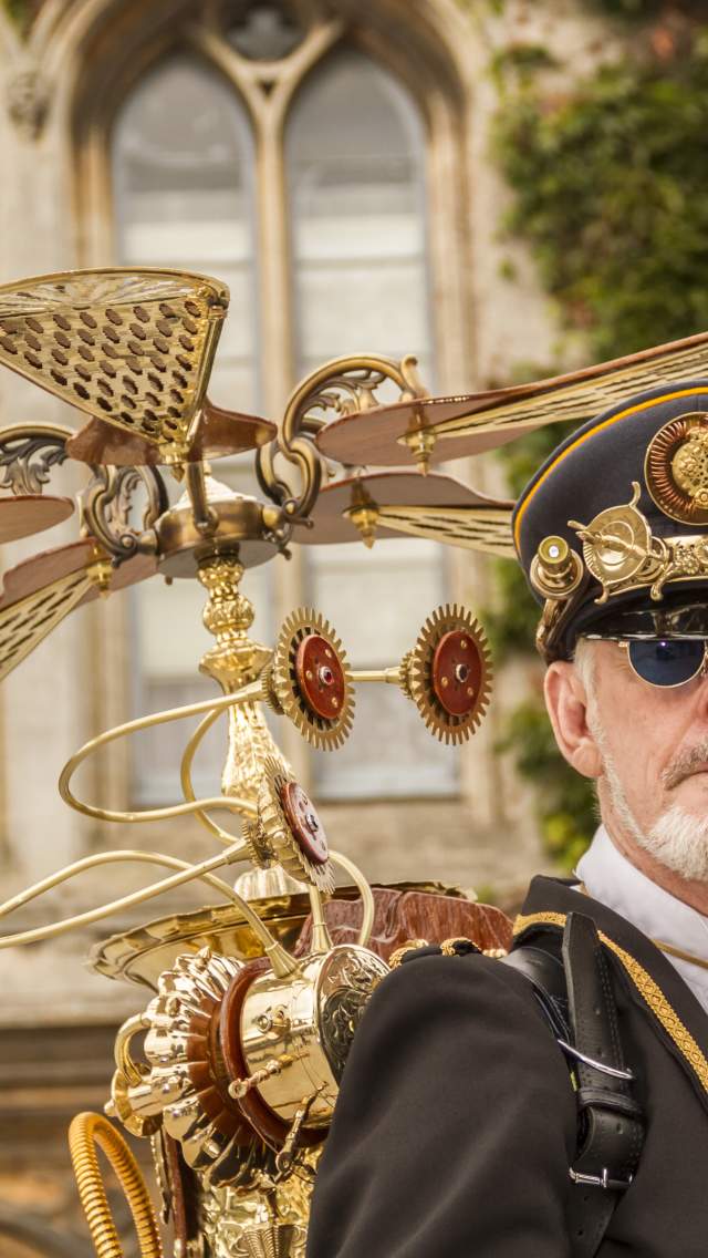 Image shows a bearded man dressed up in an elaborate Steampunk costume, in the grounds of Lincoln Castle.