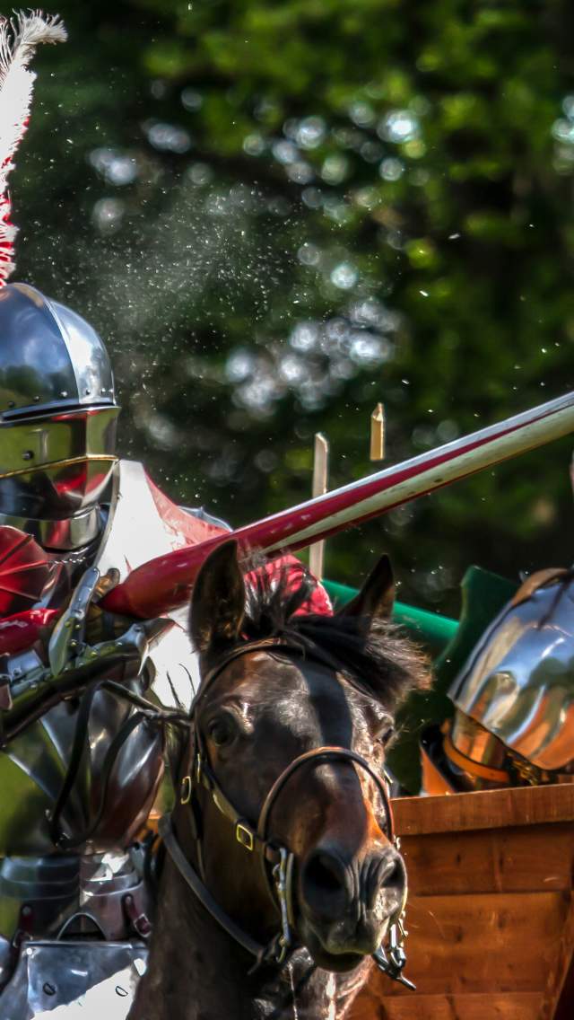 A knight holding a lance as his horse gallops through the grounds of Lincoln Castle