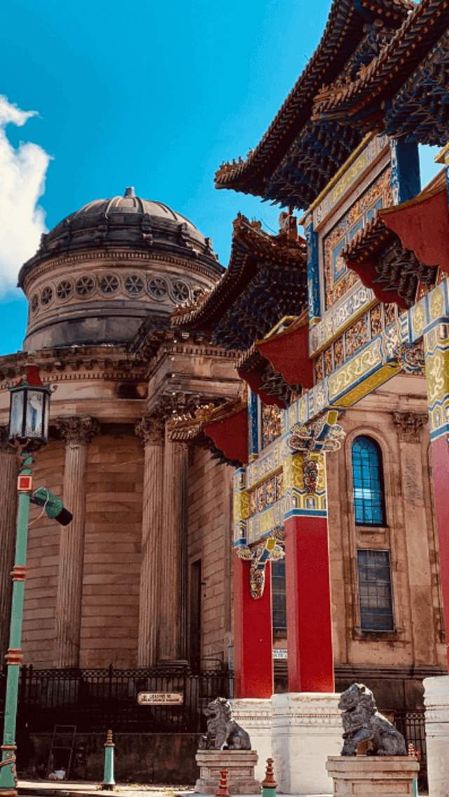 A large Chinatown Arch alongside a Grecian style building.
