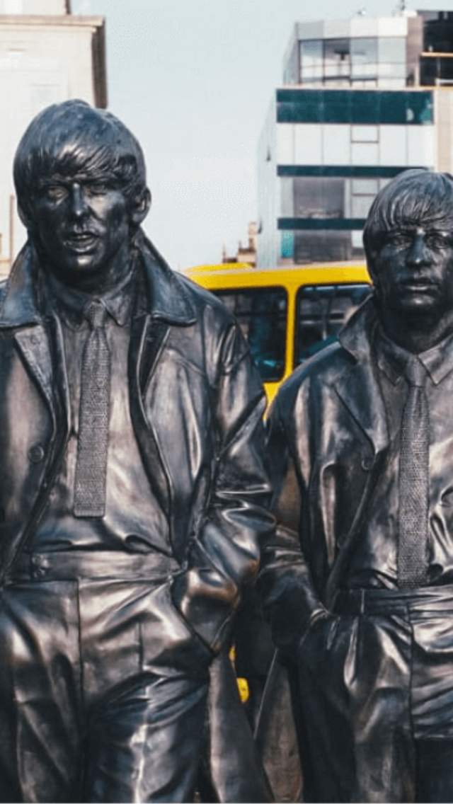Four larger than life, realistic statues of the Beatles