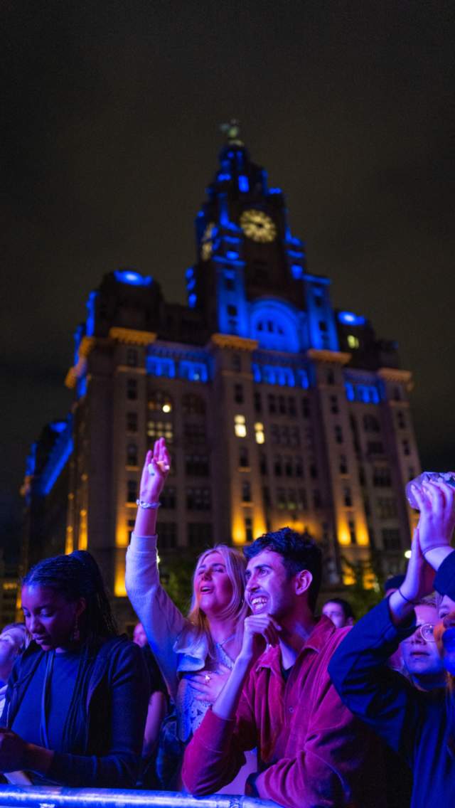 People smiling, at a concert on Liverpool Waterfront