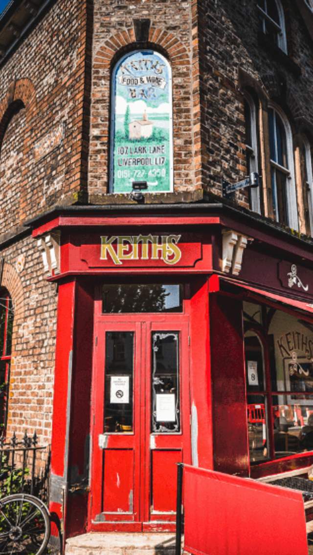 An exterior shot of a cafe with an old Victorian Style shop front painted red