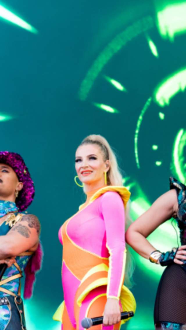 The Vengaboys standing on stage in bright, flourescent outfits