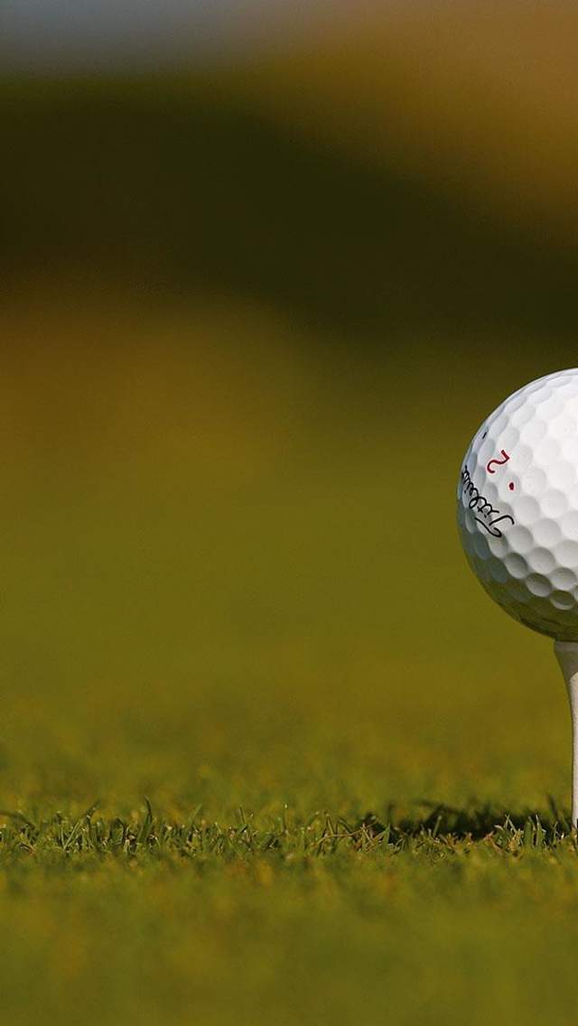 Image of a golf ball sitting on a tee at the P&O Golf tournament at Royal County Down Golf course