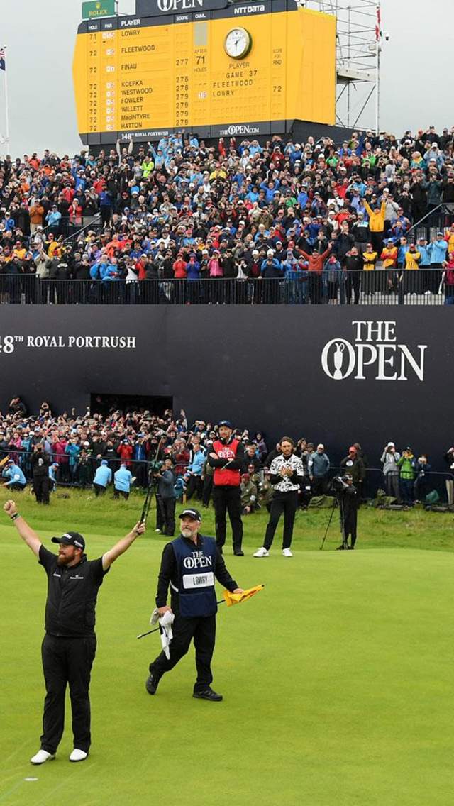 Golfer Shane Lowry celebrating his British Open win on the 18th green in front of a huge crowd