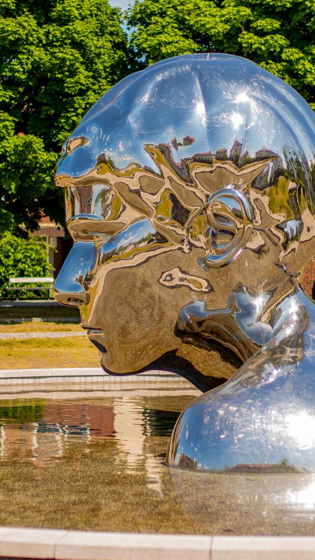 Skulpturen Genesis i krom og vannspeilet rundt, i Sarpsborg. Foto.