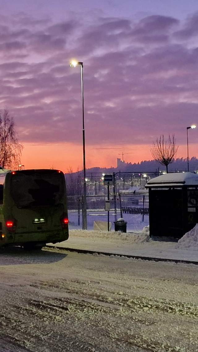 Vinterbilde som viser en bussholdeplass i Halden med busser foran.