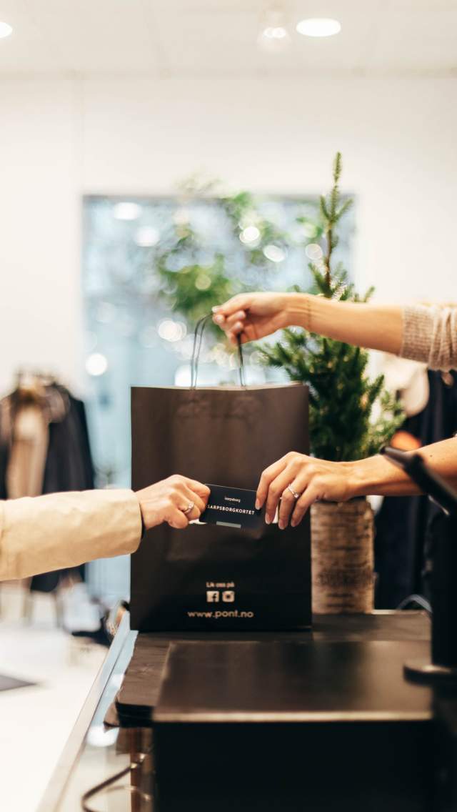 Nærbilde av en betaling med gavekortet Sarpsborgkortet i en butikk i Sarpsborg sentrum. Foto.