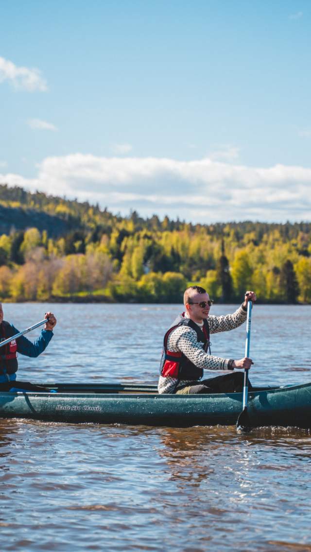 Two men are paddling a canoe in the lake.