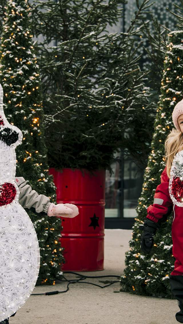 To jenter som leker ved julepynten på torget i Sarpsborg. Foto.