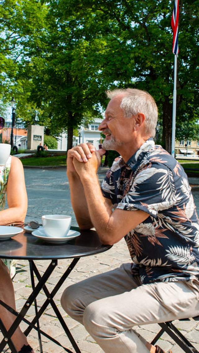 Par drikker kaffe på en fortauskafé i Halden